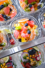 Boxes with pre-packaged fruit salads in a commercial fridge