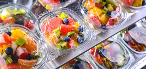 Boxes with pre-packaged fruit salads in a commercial fridge