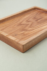 Naklejka na ściany i meble Wooden tray on green background. Сompartmental dish. Corner closeup