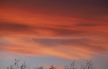 The sky is red, scarlet, brown, blue, blue at sunset. 