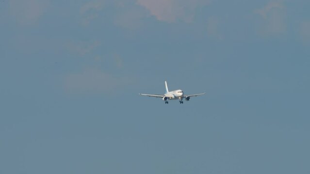 Long shot front view passenger jet aircraft approaching landing in Sochi airport. Tourism and travel concept