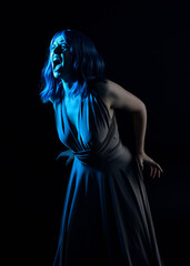 close up portrait of pretty girl with blue hair wig & elegant gown with expressive facial expressions & gestural arm poses. colourful neon gel lighting, isolated on studio background.