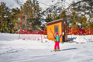 Young skier, a child, riding up on a ski drag lift and waving hand to a camera. Winter holidays in El Tarter, Andorra, Pyrenees Mountains, Grandvalira