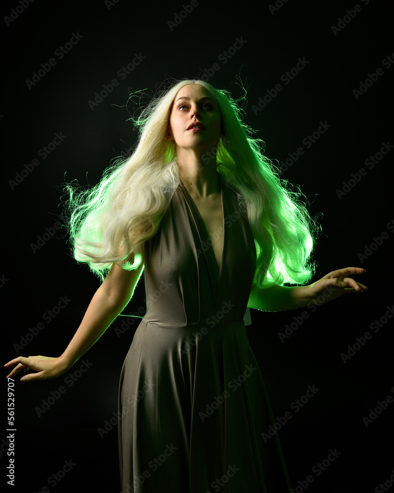 Canvas Prints portrait of pretty girl with blonde hair & elegant gown with expressive facial expressions & gestural arm poses. colourful neon gel lighting, isolated on black studio background.