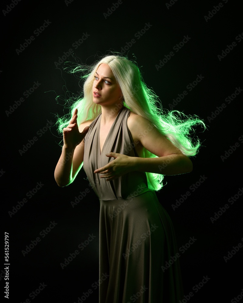 Canvas Prints portrait of pretty girl with blonde hair & elegant gown with expressive facial expressions & gestural arm poses. colourful neon gel lighting, isolated on black studio background.