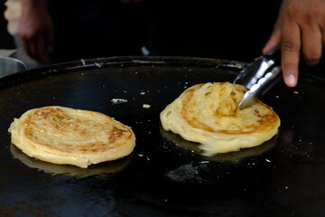 Making of Roti Canai or Roti Prata or Roti India in a festival food, traditional pancake for breakfast from Thailand, Indonesia, Singapore or Malaysia