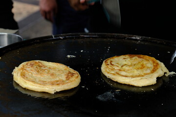 Making of Roti Canai or Roti Prata or Roti India in a festival food, traditional pancake for breakfast from Thailand, Indonesia, Singapore or Malaysia