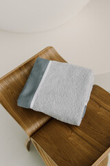 Obraz na płótnie Canvas Gray towel in bathroom. Folded fresh towel closeup