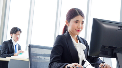 Young female employee working at a desk using a computer to work business idea.