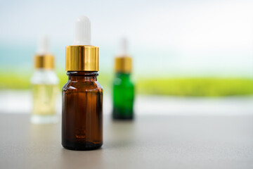 Set of multi color glass bottles with dropper on the table. Concept of aroma oil, cosmetic and beauty skin.