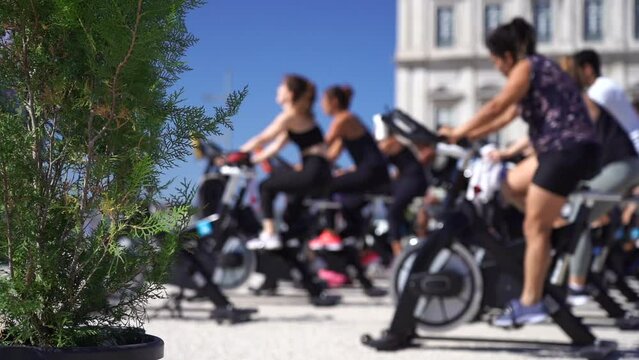 Blurred group of people cycling on machine outdoor. Healthy lifestyle, fitness, cardio concept