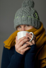 Frau zu Hause, erkältet und frierend mit Tee in der Hand