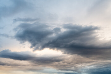 Cloudscape of grey bluish clouds in a stormy golden sky