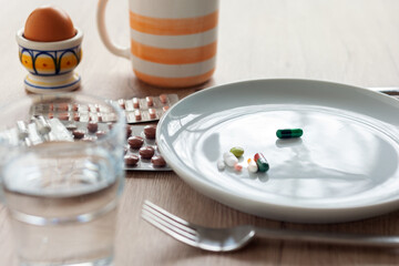 Medikamente - Frühstückstisch mit den täglichen Tablette n auf dem Teller