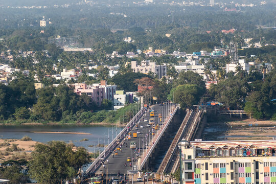 An aerial view of traffic on a road over the bridge between the towns of Tiruchirappalli and Srirangam.