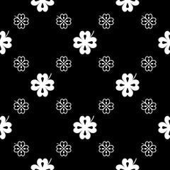 Seamless vector pattern with clover leaves. The holidays backdrop for St. Patrick's Day. White elements on the black. Festive background for greeting cards, decoration, packaging design, print and web