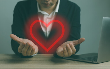 Man handing heart shape on hand .  Red heart on hand.