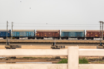 Wagons of an Indian Railways goods train crossing a bridge.