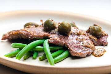 pork steak with mustard sauce with capers served with green beans