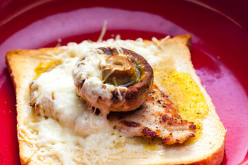 slice of  toast bread grilled with meat, champignon and cheese