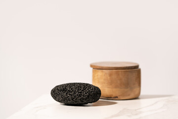 Black pumice stone on a bathroom shelf. Product presentation scene. - obrazy, fototapety, plakaty