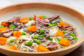 beef broth with green peas, carrot and small meatballs