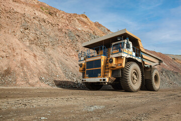 Large dump truck for removal of rock mass from the quarry for open-pit mining of minerals. Initial stage of melalurgy, machinery for the extraction of raw ore.