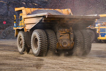 Large dump truck for removal of rock mass from the quarry for open-pit mining of minerals. Initial stage of melalurgy, machinery for the extraction of raw ore.