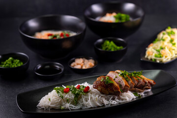 Various dishes of Asian cuisine with different types noodles and rice with shrimp, duck, vegetables and black sesame