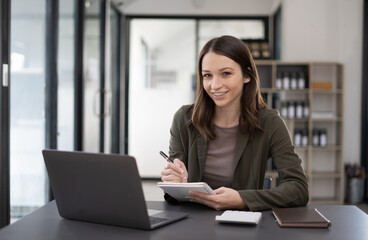 Beautiful woman at the modern office with a computer laptop.