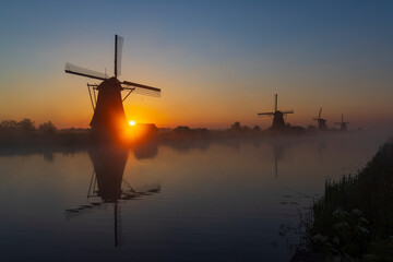 Traditional Dutch windmills with a colourful sky just before sunrise in Kinderdijk, The Netherlands