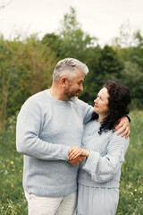 Senior couple standing in a park and looking on each other