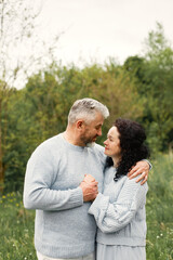 Senior couple standing in a park and looking on each other