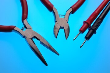 Electrical tools, wire cutters, multimeter indicator screwdriver. Multicolored background. Close-up