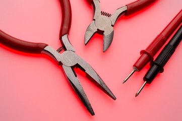 Electrical tools, wire cutters, multimeter indicator screwdriver. Multicolored background. Close-up