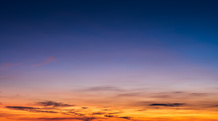 Fototapeta na wymiar Sunset sky clouds on dusk in the evening with orange sunlight and dark blue twilight 
