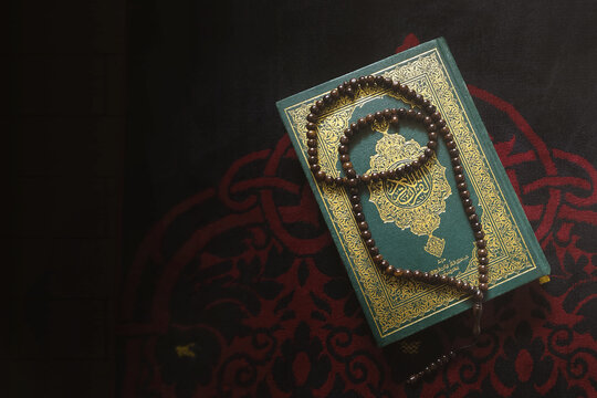 Al Quran Al Karim book with a praying carpet background and tasbih. Ramadan concept