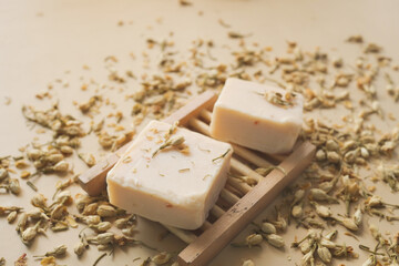 Homemade natural soap bar and dry flower on black background 