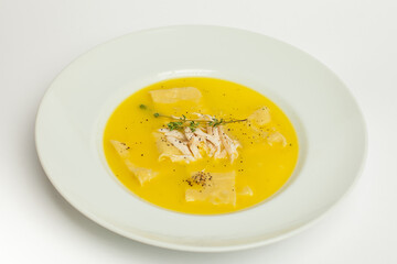 Chicken soup on white. Homemade fresh creamy soup with chicken, vegetables  in white bowl close up