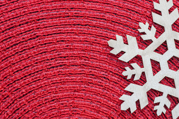 Laser-cut wooden snowflake on a red placemat. Christmas decoration concept