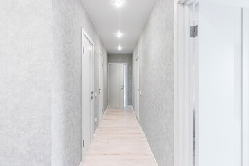 Corridor in with white walls and doors in the apartment