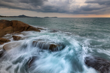 Obraz premium Artistic seascape with blurry waves crashing against granite rocks on the shore, Samui, Thailand