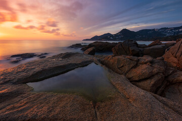 Artistic seascape with granite rocks on sea coast in front of colorful sunrise sky Samui Thailand