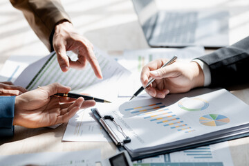 Businessman is reviewing monthly sales documents for analysis and marketing plans for more sales growth, they are the founders of young companies co-founding startups. Sales management concept.