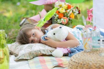 Beautiful little girl. Summer picnic. Relaxation. Holidays. Rest in the park