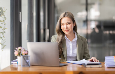 portrait of business Asian woman Accounting using calculating income-expenditure and analyzing real estate investment data report Financial and tax systems concept.	