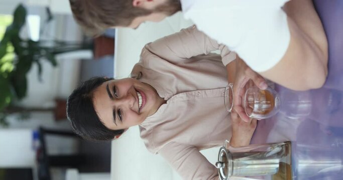 Young smiling attractive Indian woman enjoy romantic speed dating, sit at table at restaurant drink tea, lead pleasant conversation meet with Caucasian boyfriend. Romance, relationship, communication