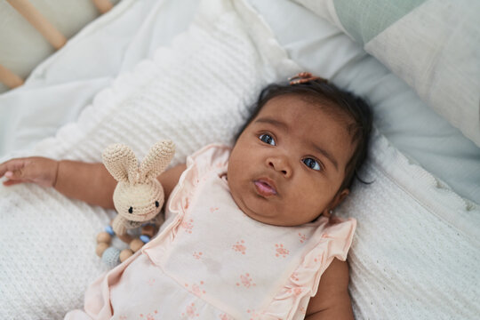 African american baby lying on bed with relaxed expression at bedroom