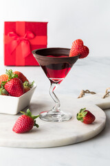 A chocolate dipped Valentine's Day cocktail garnished with a heart strawberry.