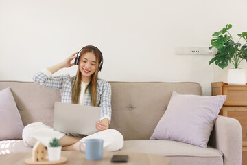 Leisure time concept, Women sitting on comfortable couch and wearing headphone to watching movie